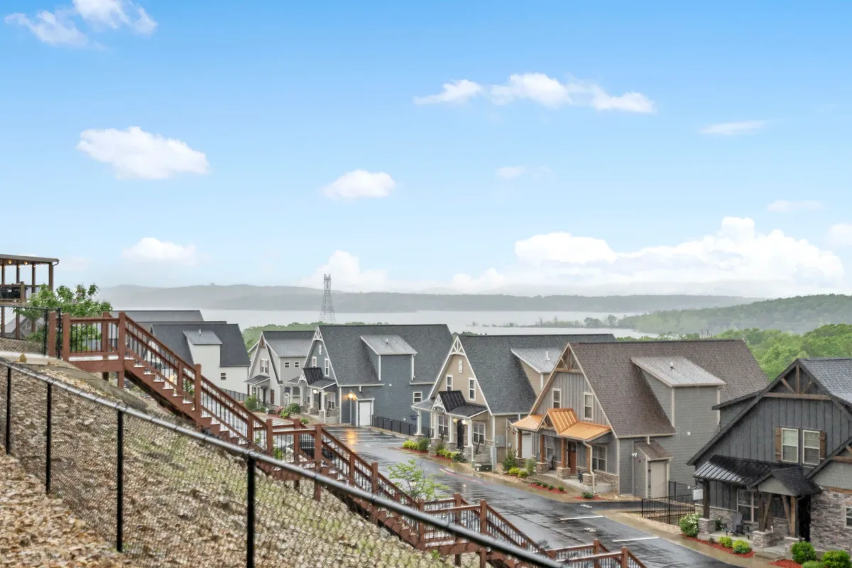 A wide exterior view featuring residential homes, landscaped pathways, and open green spaces. The image conveys a peaceful, walkable environment suitable for outdoor leisure, walking meetings, or team-building exercises.