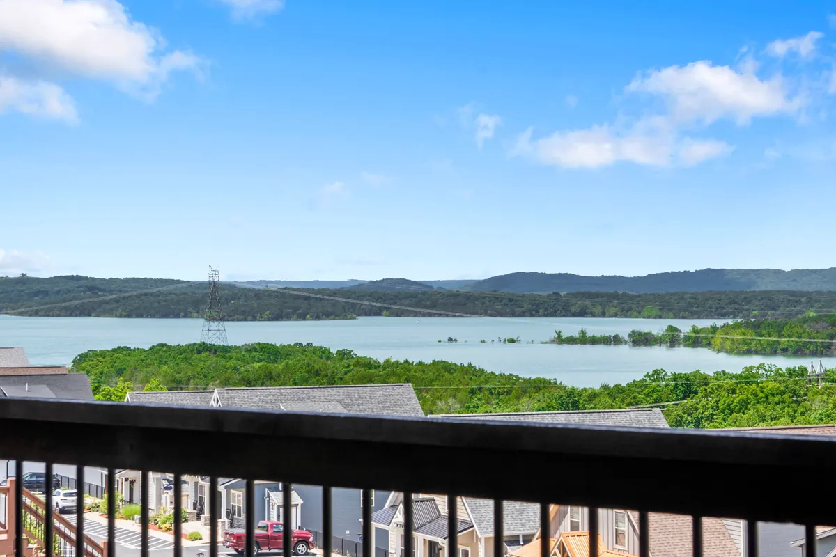 This scenic view captures Table Rock Lake with rolling hills, a wide sky, and surrounding houses, evoking the tranquil, natural setting close to the lodge. The scene highlights the accessibility of lakeside trails and parks for exploring with pets.